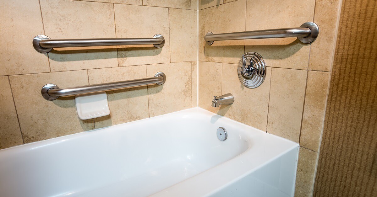 handicapped access bathtub in a hotel room with grab bar hand rail